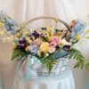 Large basket flower arrangement with matthiola, orchids, alstroemeria, roses, lisianthus, delphinium and ferns