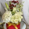Medium square box floral arrangement with hydrangeas, roses, lilies, cabbage flowers, orchids and hypericum berries