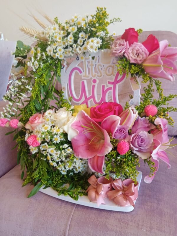 Medium floral stand with lilies, asters, solidaster, roses, spray roses and ceramic baby boots