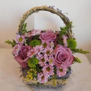 Small basket arrangement with five roses, green and purple chrysanthemums, and solid asters
