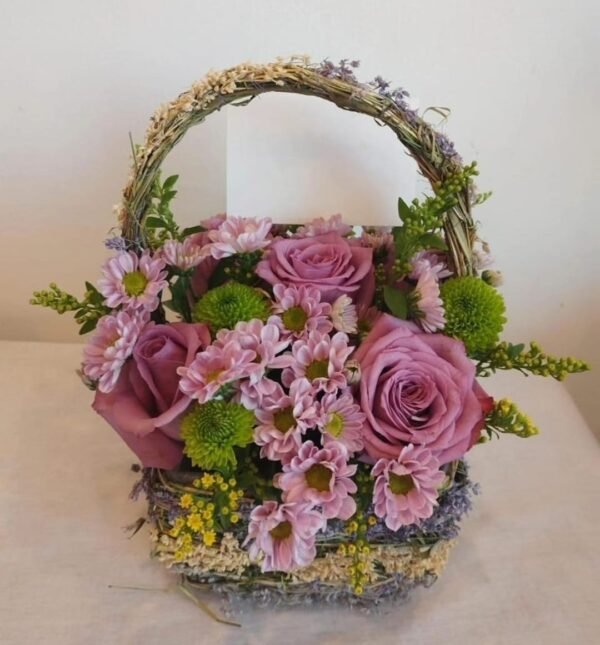 Small basket arrangement with five roses, green and purple chrysanthemums, and solid asters